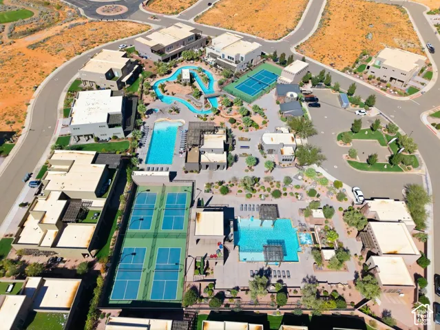 Aerial perspective of a community featuring multiple swimming pools, a lazy river, tennis courts, and pickleball courts