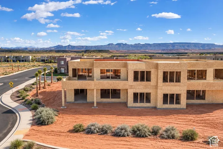 Multi-level structural framing featuring expansive window openings, high-desert landscaping, and mountain backdrops