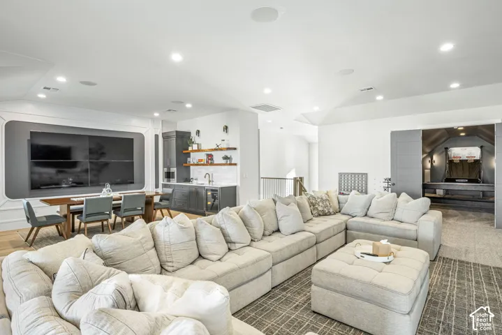 Recessed lighting, built-in cabinetry, wet bar with subway tile backsplash, recessed wall feature, and double-door entry