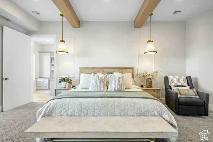 Room featuring exposed wood ceiling beams, decorative wall molding, and dual metallic pendant light fixtures