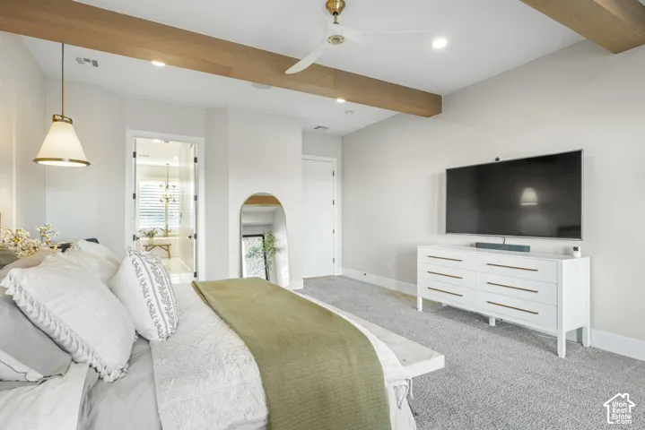 Exposed wood-finish ceiling beams, recessed lighting, arched wall niche, and metal pendant light fixture