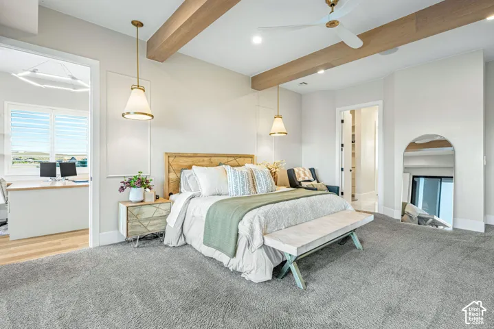 Exposed wood ceiling beams, recessed lighting, dual pendant lights, wall-mounted trim detailing, and a prominent arched-top floor mirror