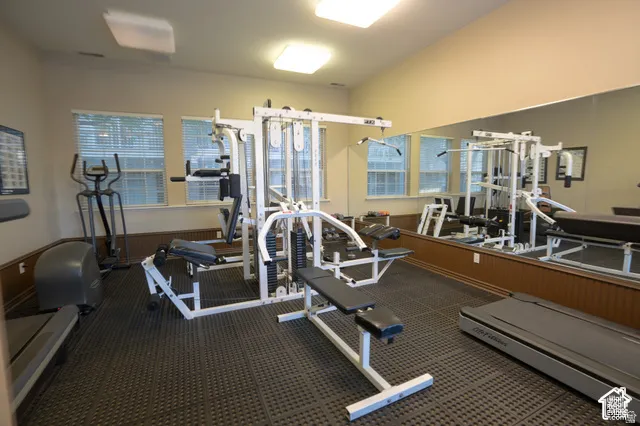 Large wall-mounted mirror, rubberized flooring, beadboard wainscoting, and multi-pane windows