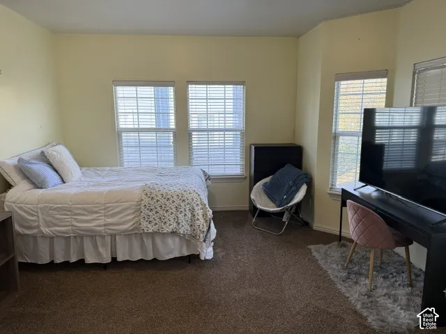 Room featuring neutral wall tones, wall-to-wall carpeting, multiple windows with fitted blinds, and a bay window configuration