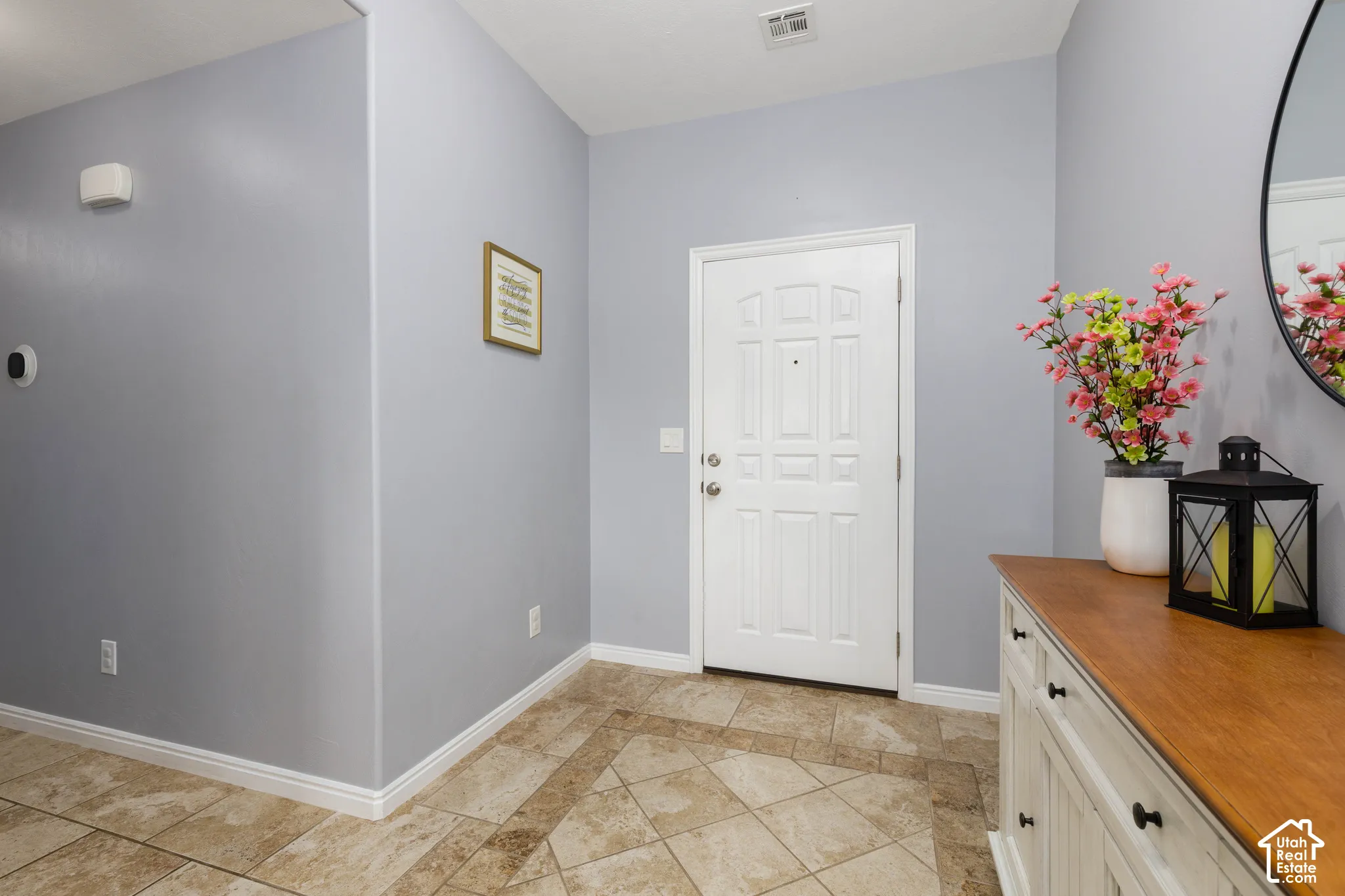 Entryway featuring a white paneled front door and ceramic tile flooring with a decorative border inlay
