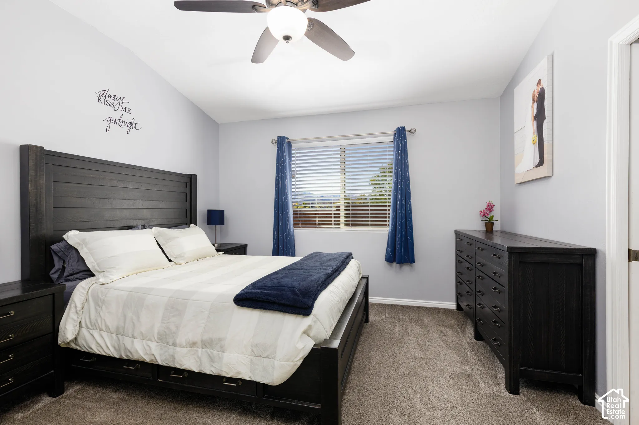 Vaulted ceiling featuring a central brushed-metal ceiling fan with integrated lighting, neutral wall paint, and carpeted flooring