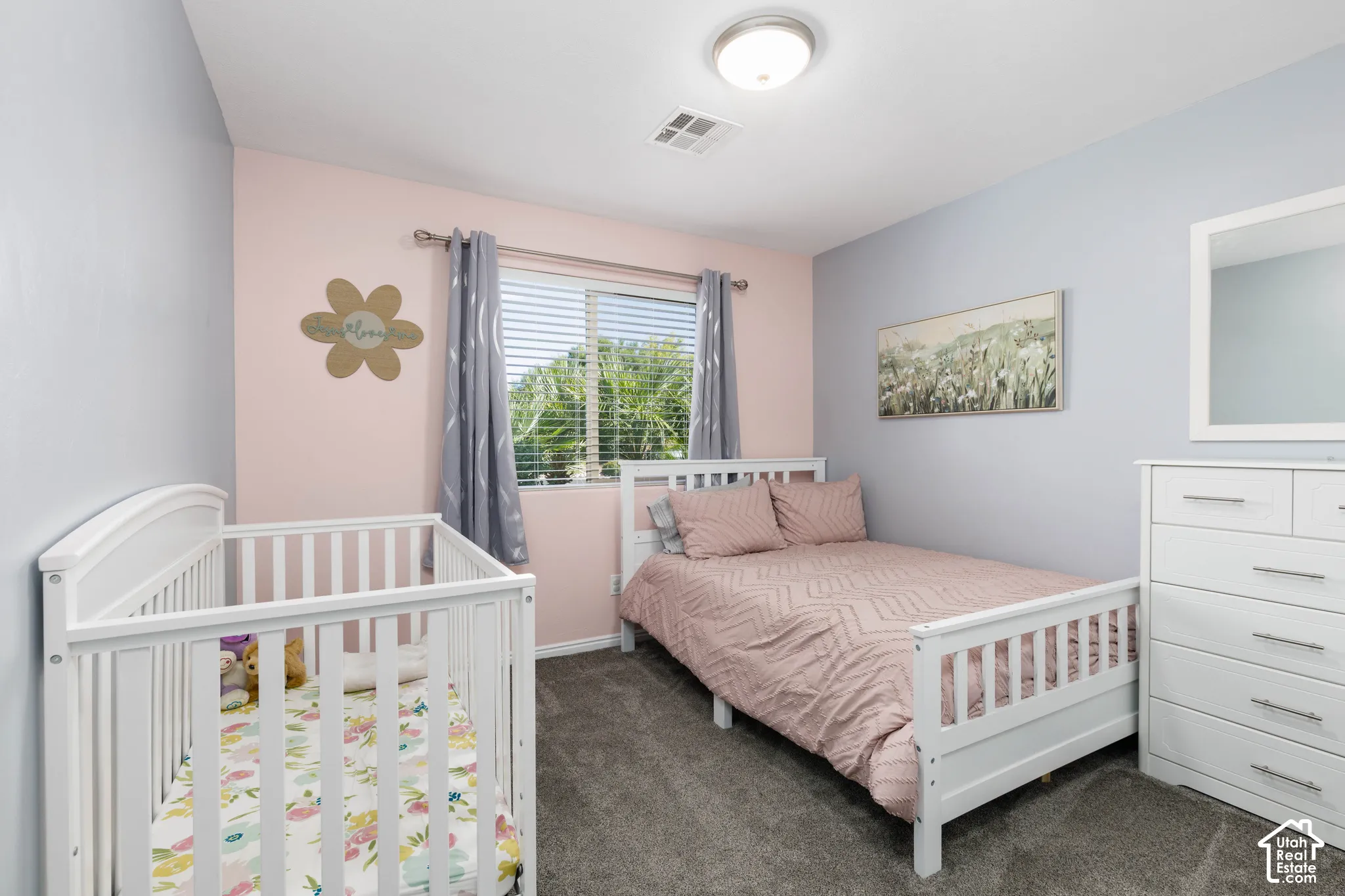 Neutral-toned carpeted flooring, two-tone painted walls, and a window with horizontal blinds