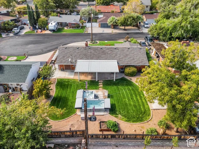 Backyard featuring a covered patio, concrete hardscaping, a lawn, and an in-ground spa
