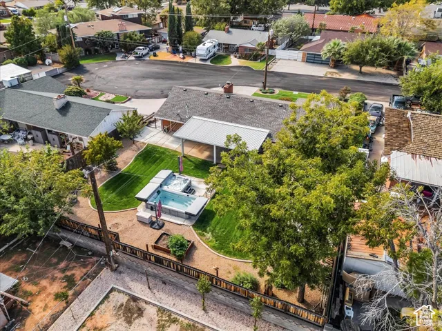 Backyard featuring a covered patio, manicured lawn, built-in spa, raised garden bed, and wood-finish perimeter fencing
