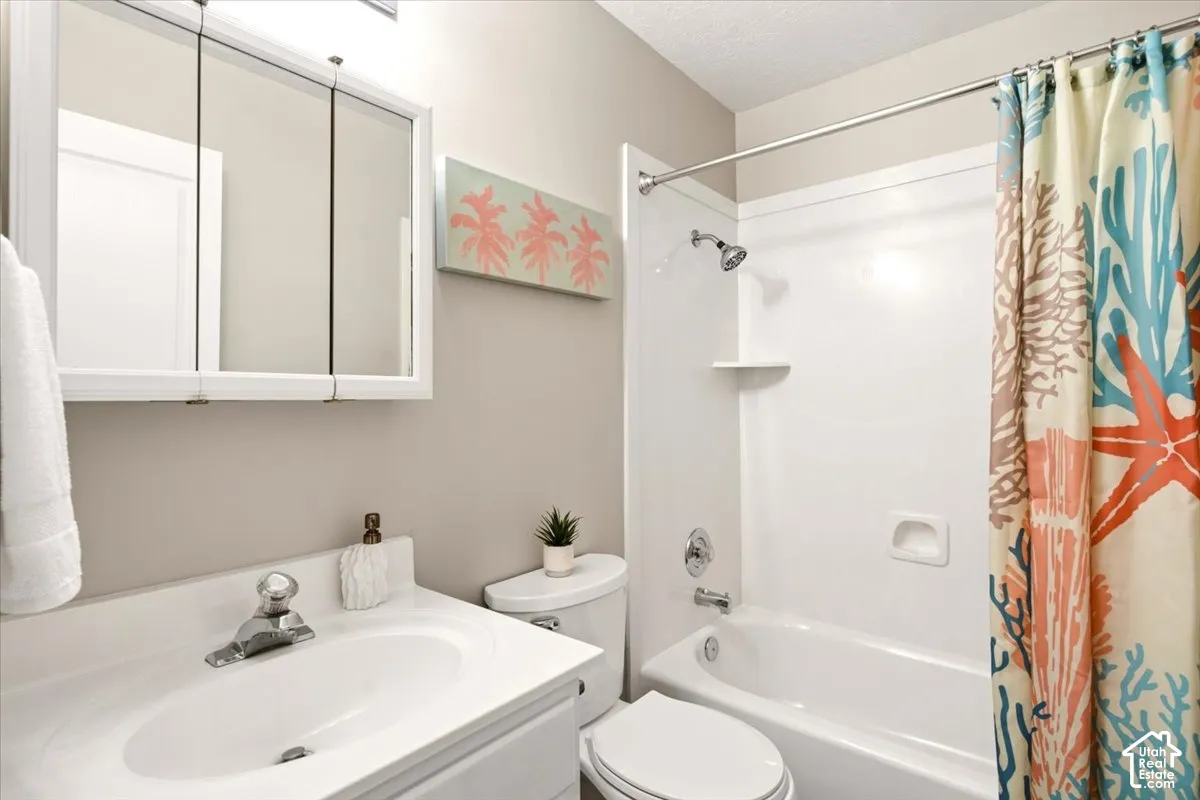 2nd bathroom featuring a vanity with integrated sink, tri-fold mirrored medicine cabinet, and a white tub-shower combination with chrome hardware