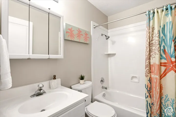2nd bathroom featuring a vanity with integrated sink, tri-fold mirrored medicine cabinet, and a white tub-shower combination with chrome hardware