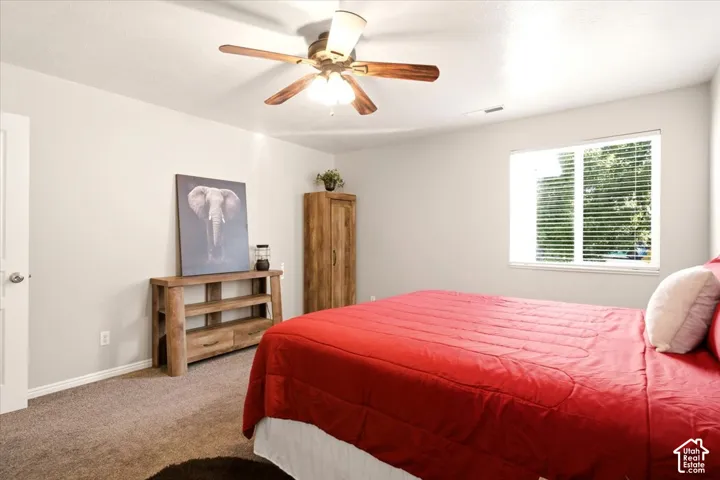 Owner suite, neutral-toned interior space featuring wall-to-wall carpeting, large enough for a king-size bed.