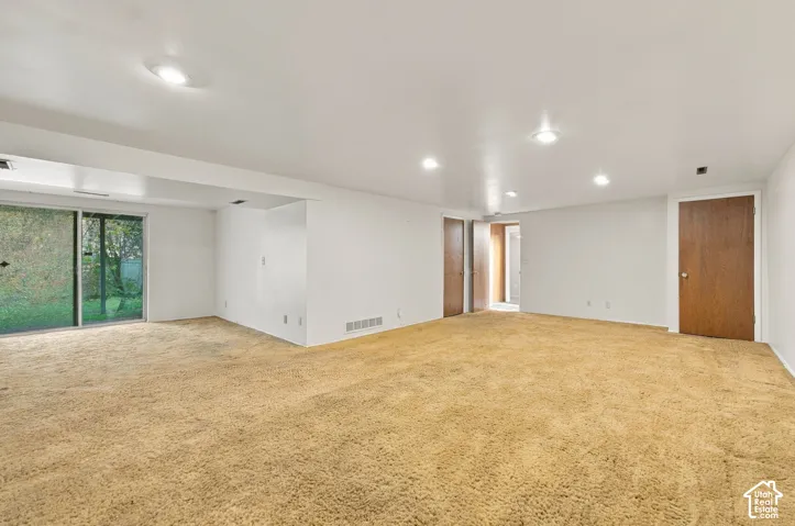 Open interior space featuring recessed ceiling lighting, wall-to-wall carpeting, and a sliding glass door