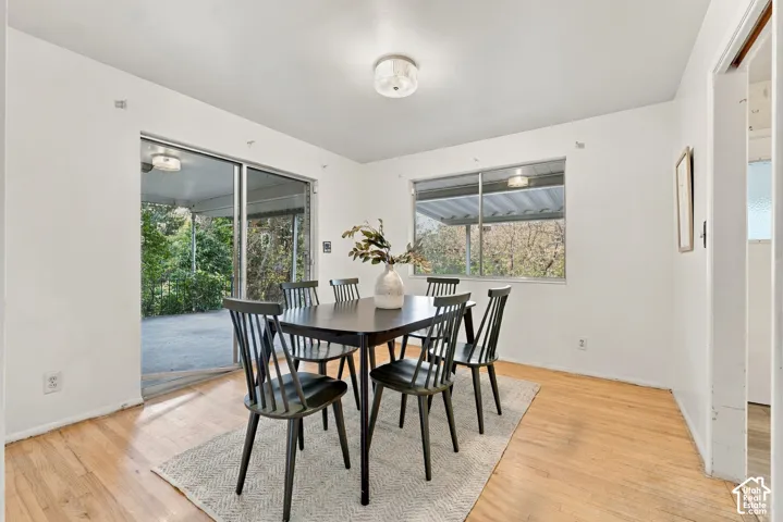 Bright interior space featuring wood-finish flooring, sliding glass door, oversized window, and flush-mount ceiling lighting