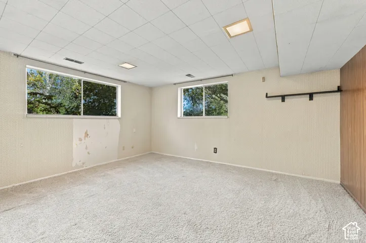 Room featuring wall-to-wall carpeting, dual horizontal sliding windows, recessed ceiling lighting, and a textured wall finish