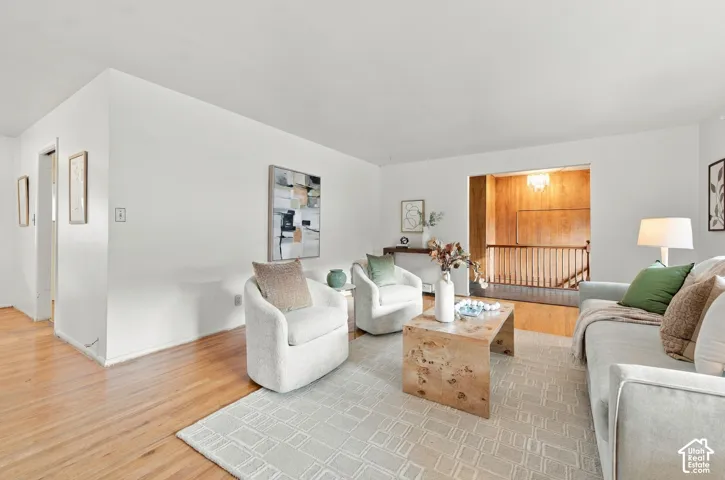Living area featuring wood-finish flooring and wood-slat staircase railing