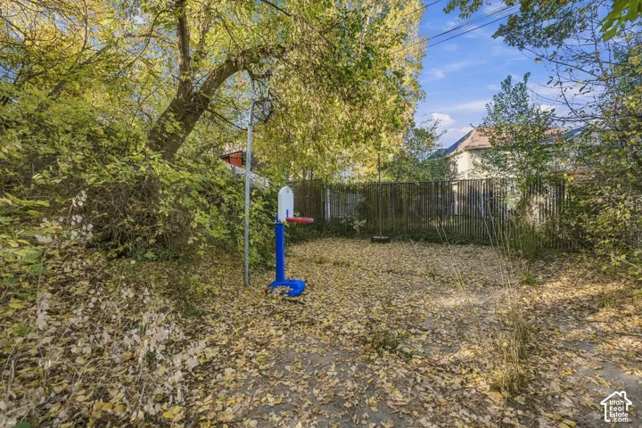 Private backyard featuring a metal fence perimeter and mature trees