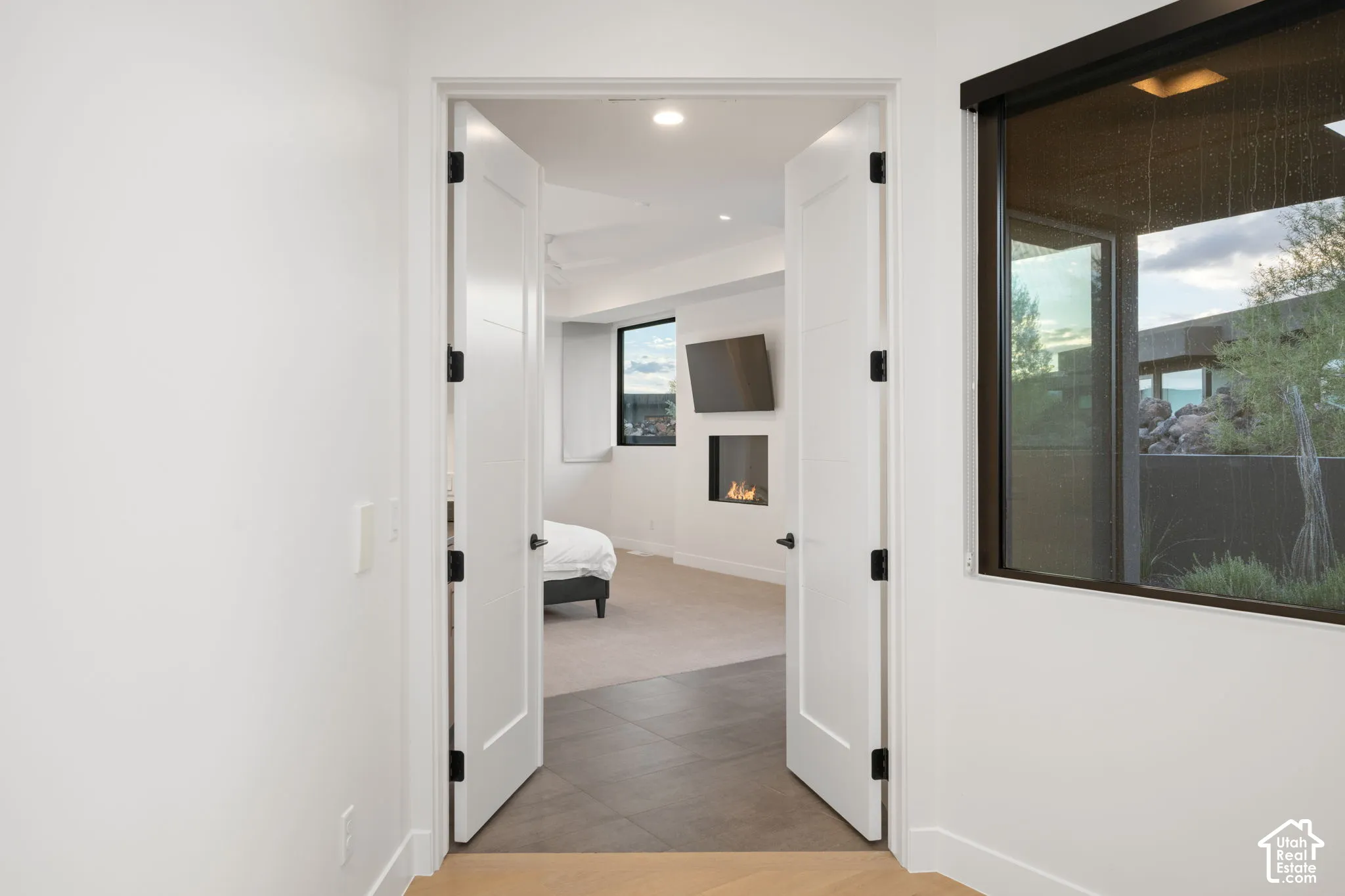 Double-door entry featuring recessed lighting, large-format tile flooring, and a linear built-in fireplace