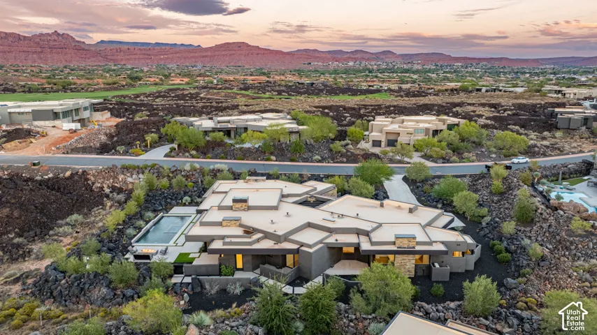 Contemporary single-level residence featuring a flat roofline, stone veneer accents, an inground swimming pool, and native desert landscaping