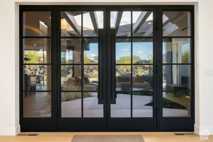 Black metal-framed double glass doors with multi-lite panes and elongated vertical handles