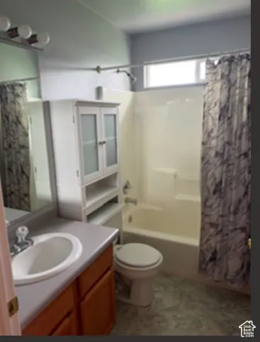 Bathroom featuring a vanity with integrated sink, built-in cabinet with frosted glass inserts, bathtub and shower combination with surround, and transom window