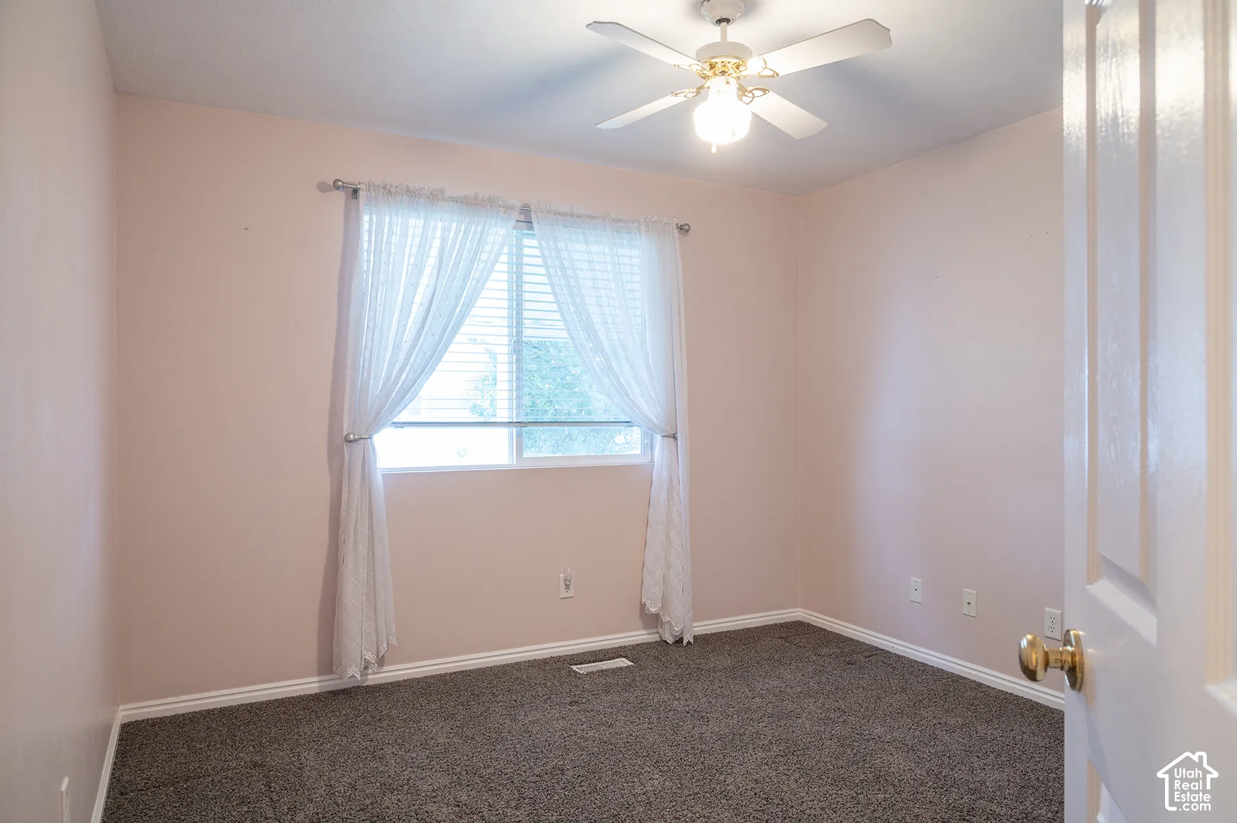 Room featuring wall-to-wall carpeting, a multi-blade ceiling fan with an integrated light fixture, and a sliding window