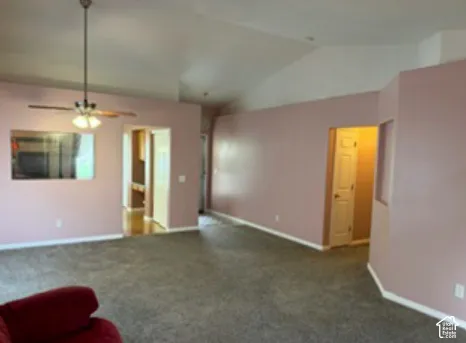 Vaulted ceilings, built-in wall niche, and brushed nickel ceiling fan with integrated light fixture