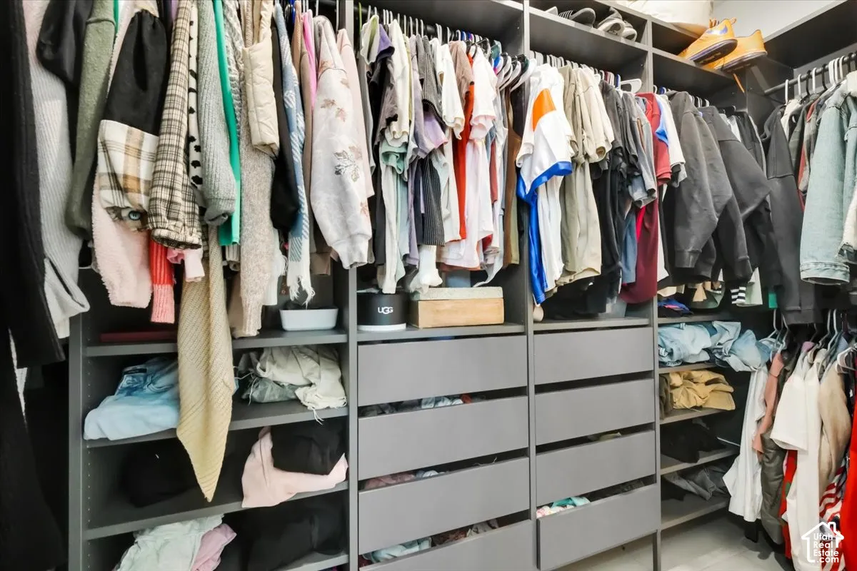 Custom storage system featuring floor-to-ceiling cabinetry, integrated hanging rods, and multi-tier built-in drawers