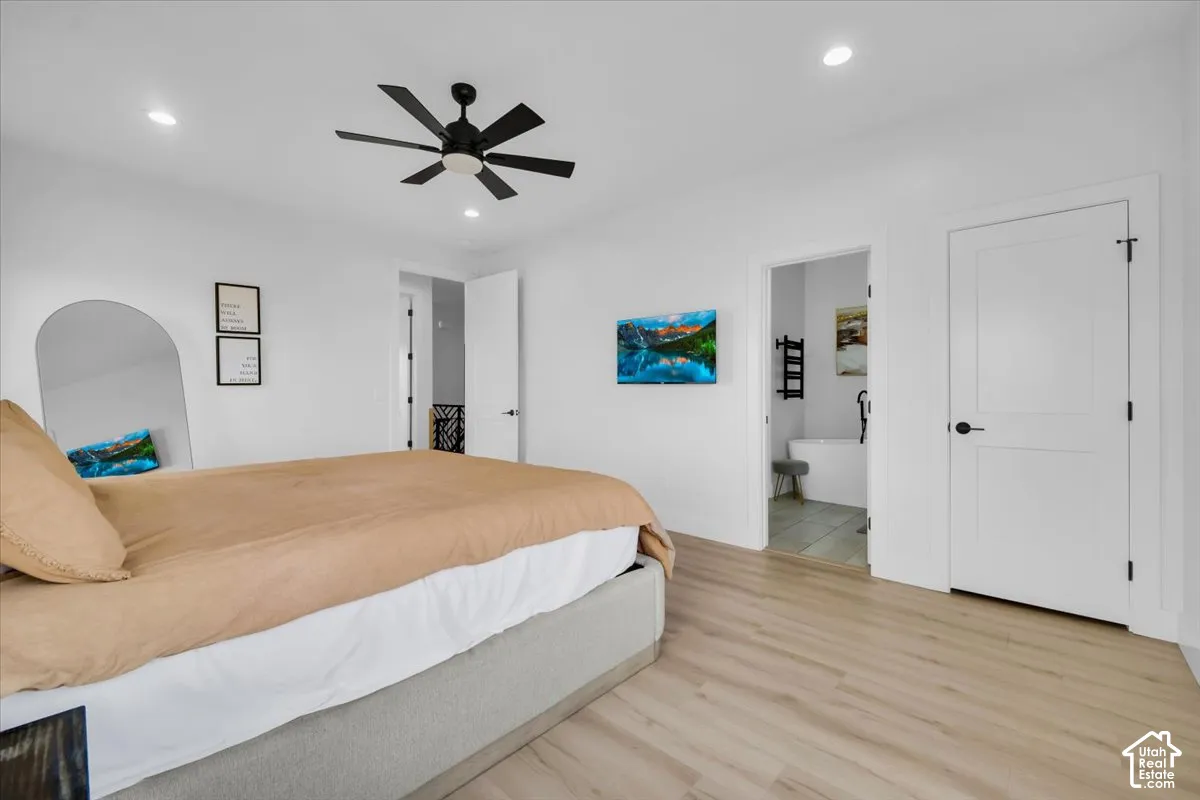 Wood-finish flooring, recessed lighting, matte black ceiling fan, and shaker-style interior doors with matte black hardware
