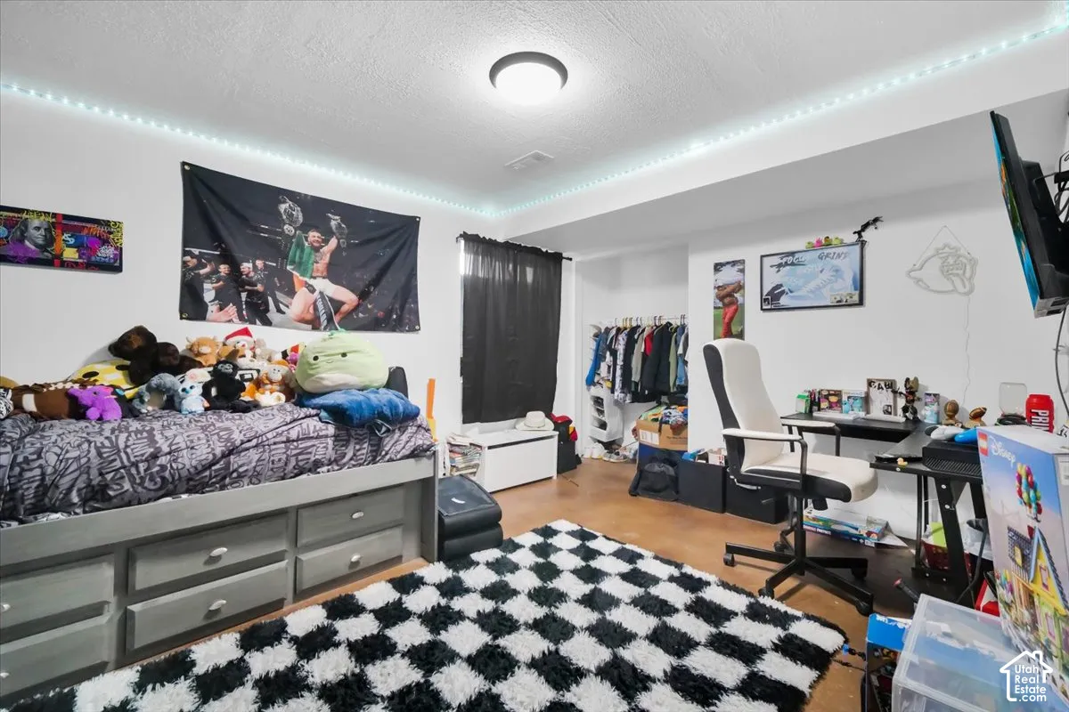 Neutral-toned room featuring a recessed storage nook, integrated perimeter crown molding lighting, and hard-surface flooring