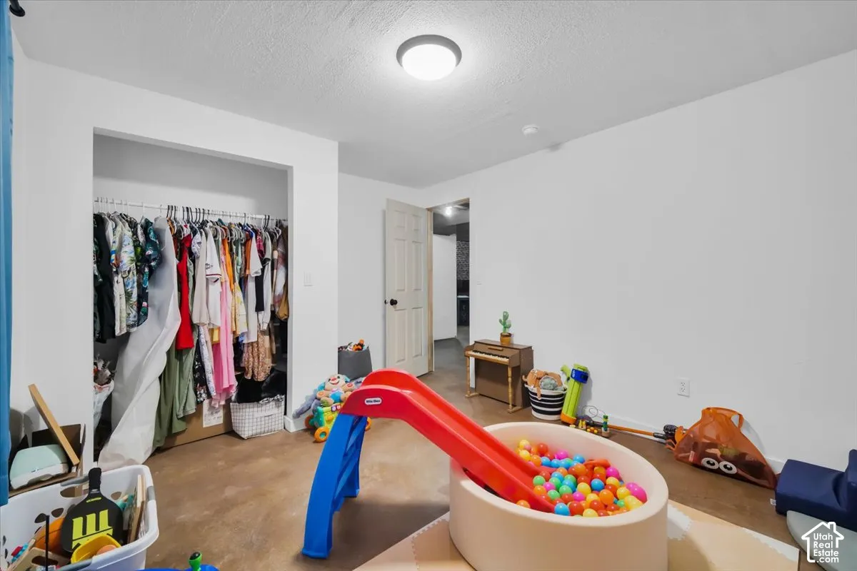 Interior room featuring neutral wall paint, hard-surface flooring, a recessed closet with built-in shelving and hanging rods, and a flush-mount ceiling light fixture