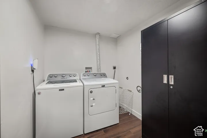 Laundry room featuring wood-finish flooring and full-height built-in matte black cabinetry