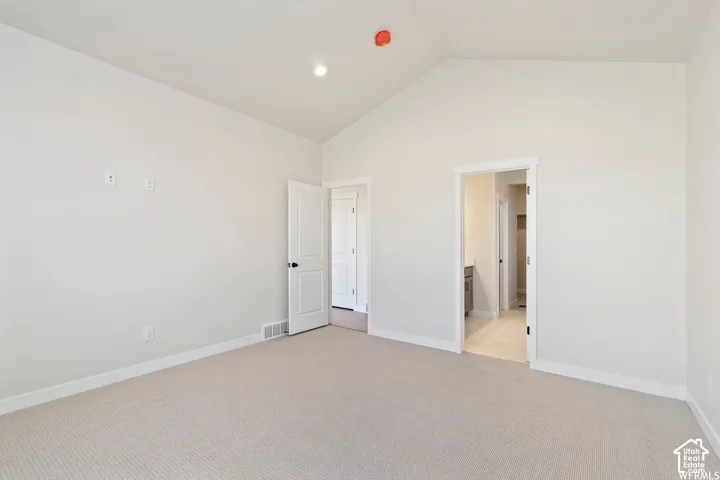 Vaulted ceilings, neutral carpeting, and solid-core interior doors with matte black hardware