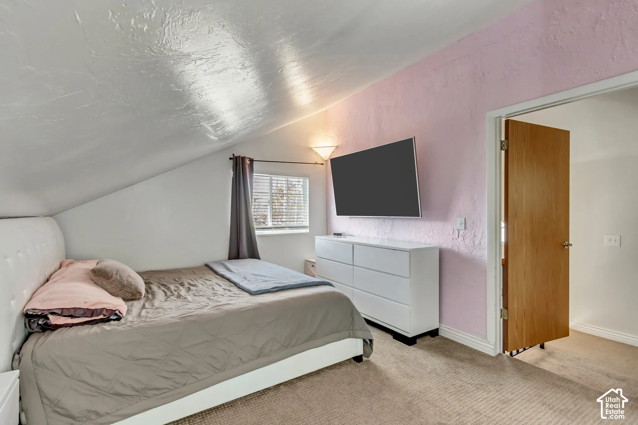 Sloped ceiling with recessed wall sconce, horizontal sliding window, and solid core wood door