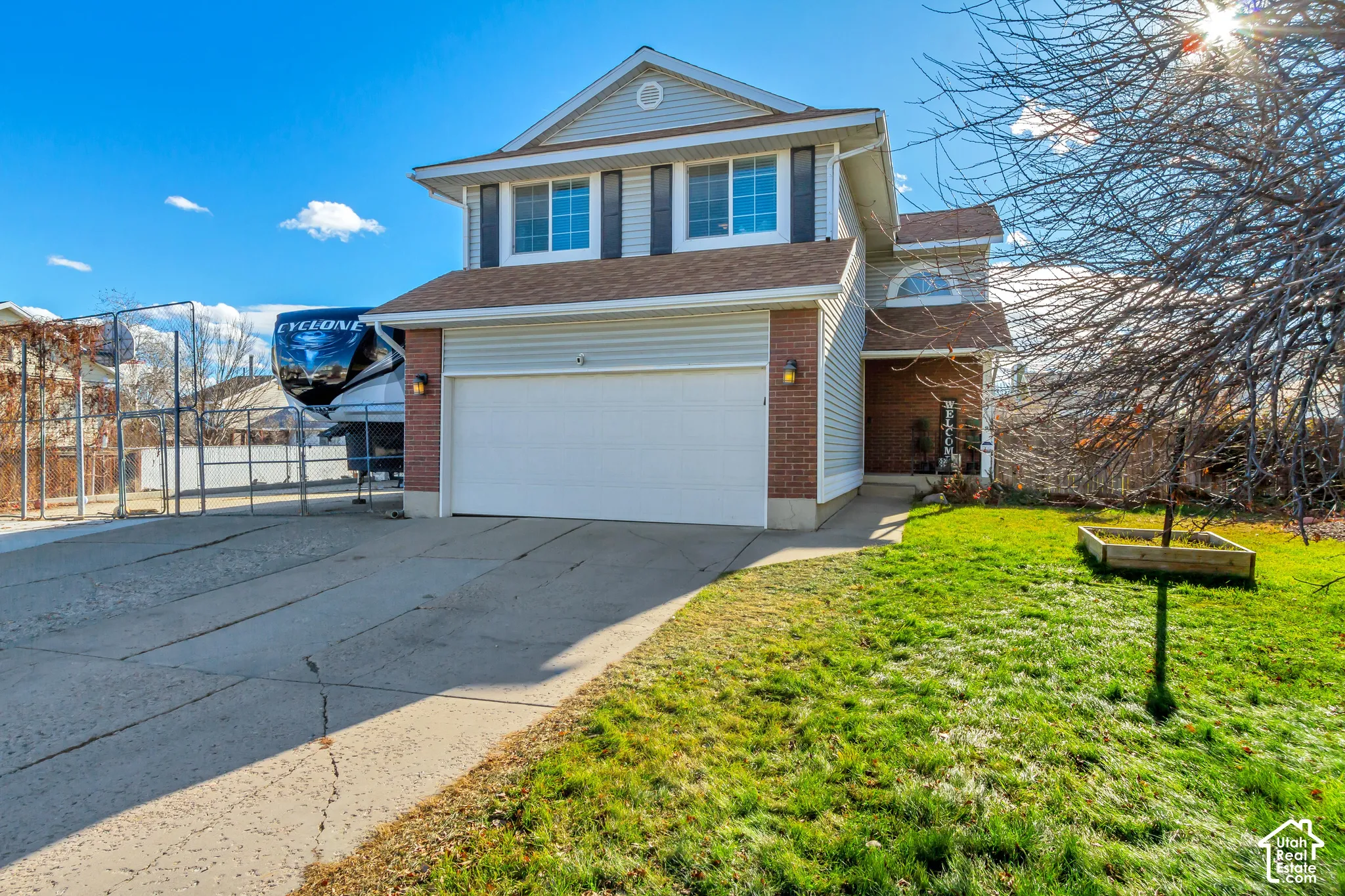 Two-story residence featuring a brick and vinyl siding exterior, an attached two-car garage, and a concrete driveway