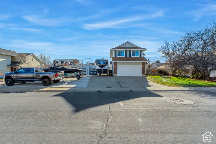 Two-story exterior featuring a gabled roof, an attached two-car garage, and a concrete driveway providing supplemental parking