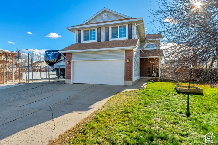 Two-story residence featuring a brick and vinyl siding exterior, an attached two-car garage, and a concrete driveway
