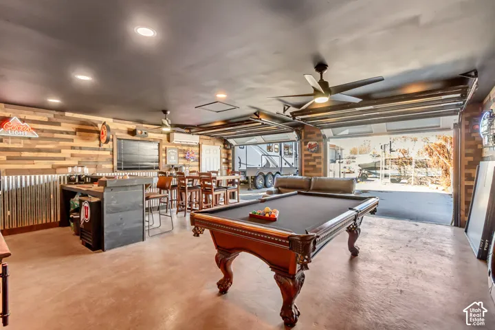 Finished garage space featuring wood-plank wall treatments, corrugated metal wainscoting, recessed lighting, ceiling fans, and a built-in counter area