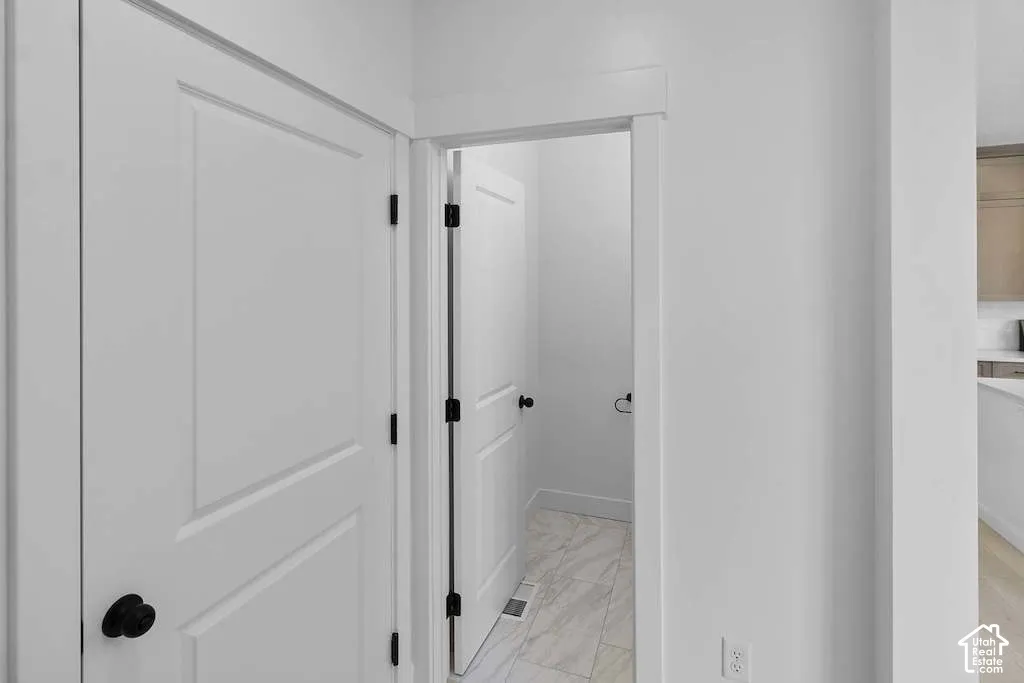 Interior featuring solid-core doors with matte black hardware and stone-finish tile flooring