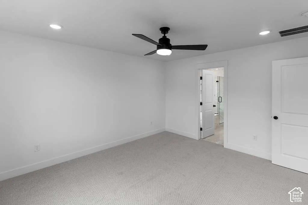 Interior space featuring neutral wall-to-wall carpeting, recessed ceiling lighting, and a modern matte black ceiling fan with an integrated light fixture