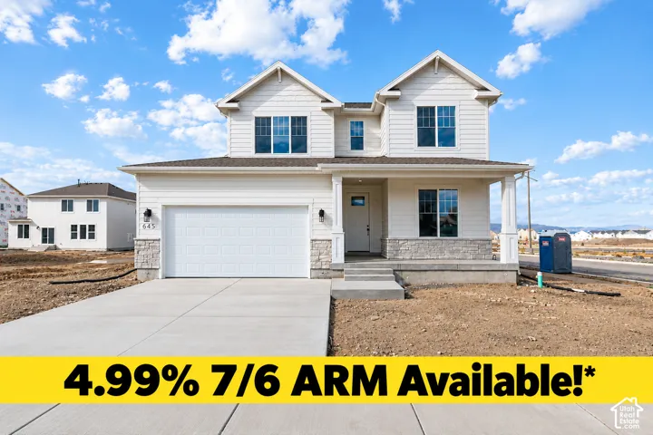 Two-story residence with horizontal siding, stone veneer accents, a covered front porch, and a two-car garage