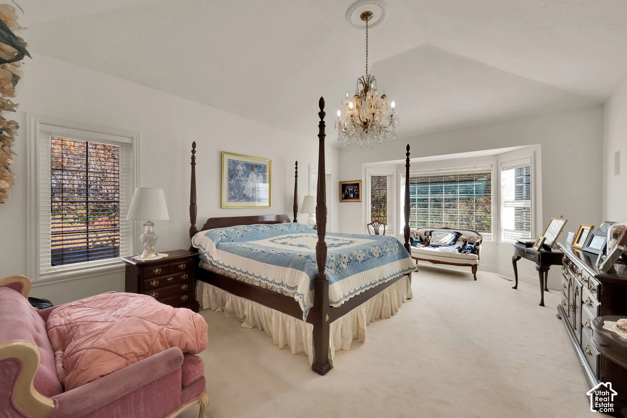 Vaulted ceilings, crystal chandelier with a ceiling medallion, bay window, and neutral wall-to-wall carpeting