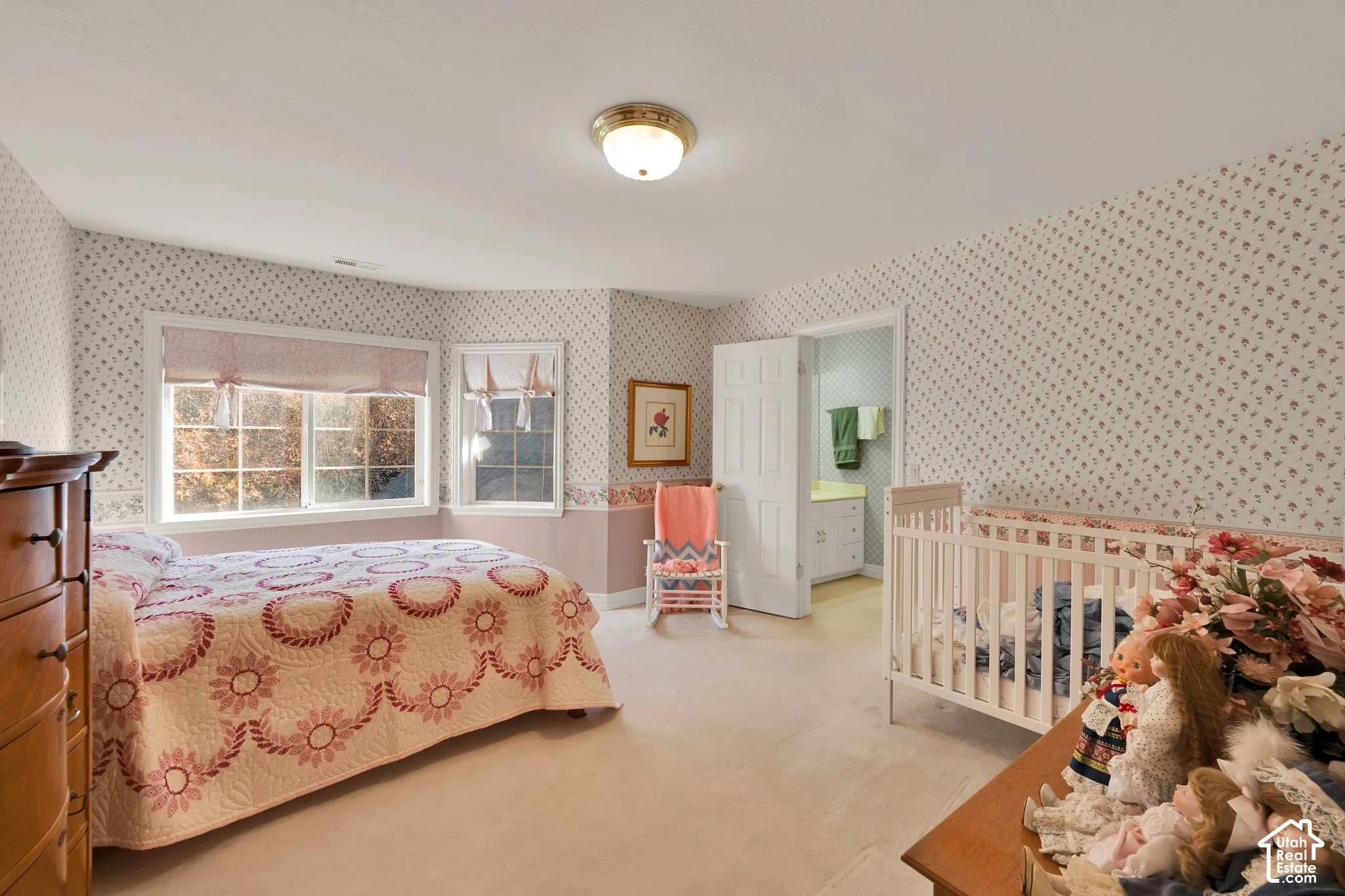 Bedroom interior featuring a multi-pane bay window, neutral carpeting, and a six-panel door
