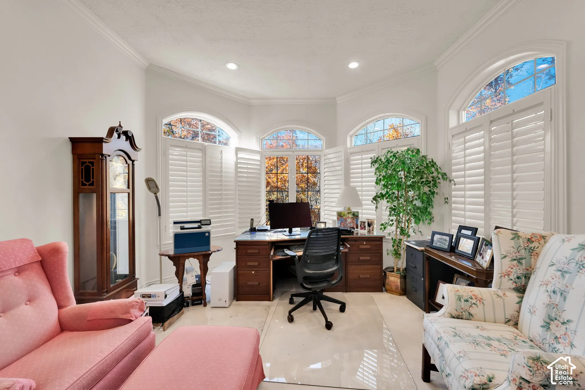 Bay window configuration featuring arched transom windows and white plantation shutters, accompanied by recessed ceiling lighting and smooth-surface flooring