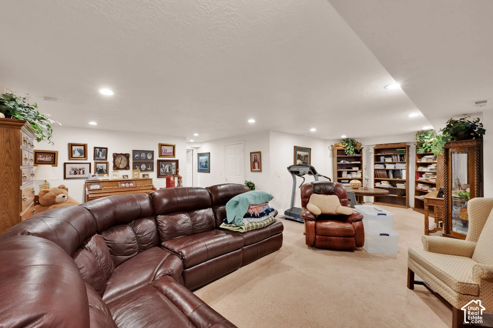 Open-concept room featuring recessed lighting, neutral carpeting, and built-in wood shelving
