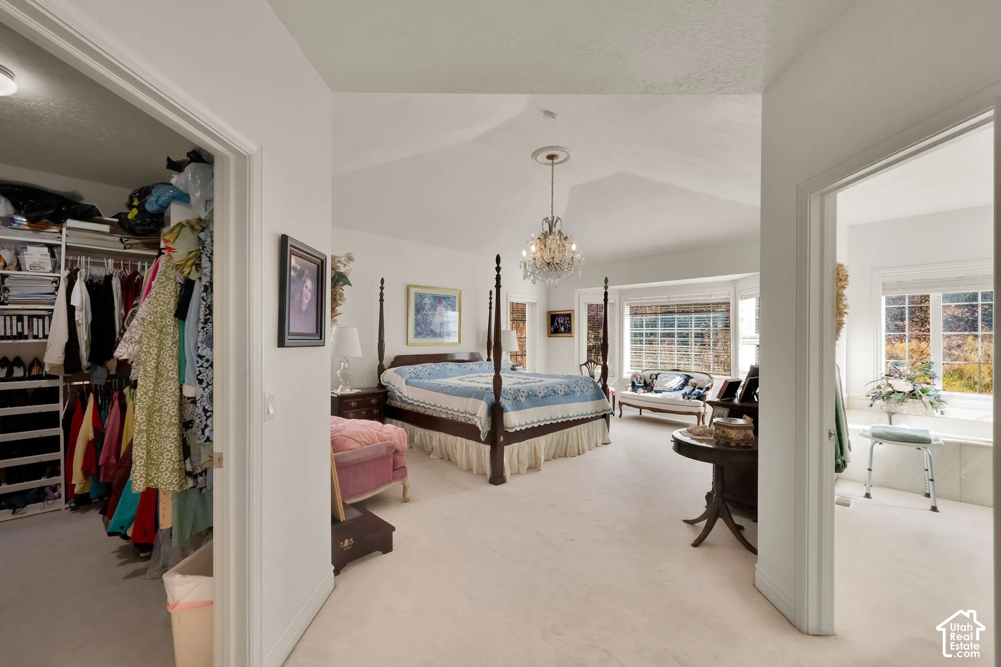 Vaulted ceiling, crystal chandelier, walk-in closet with built-in shelving, bay window, and soaking tub