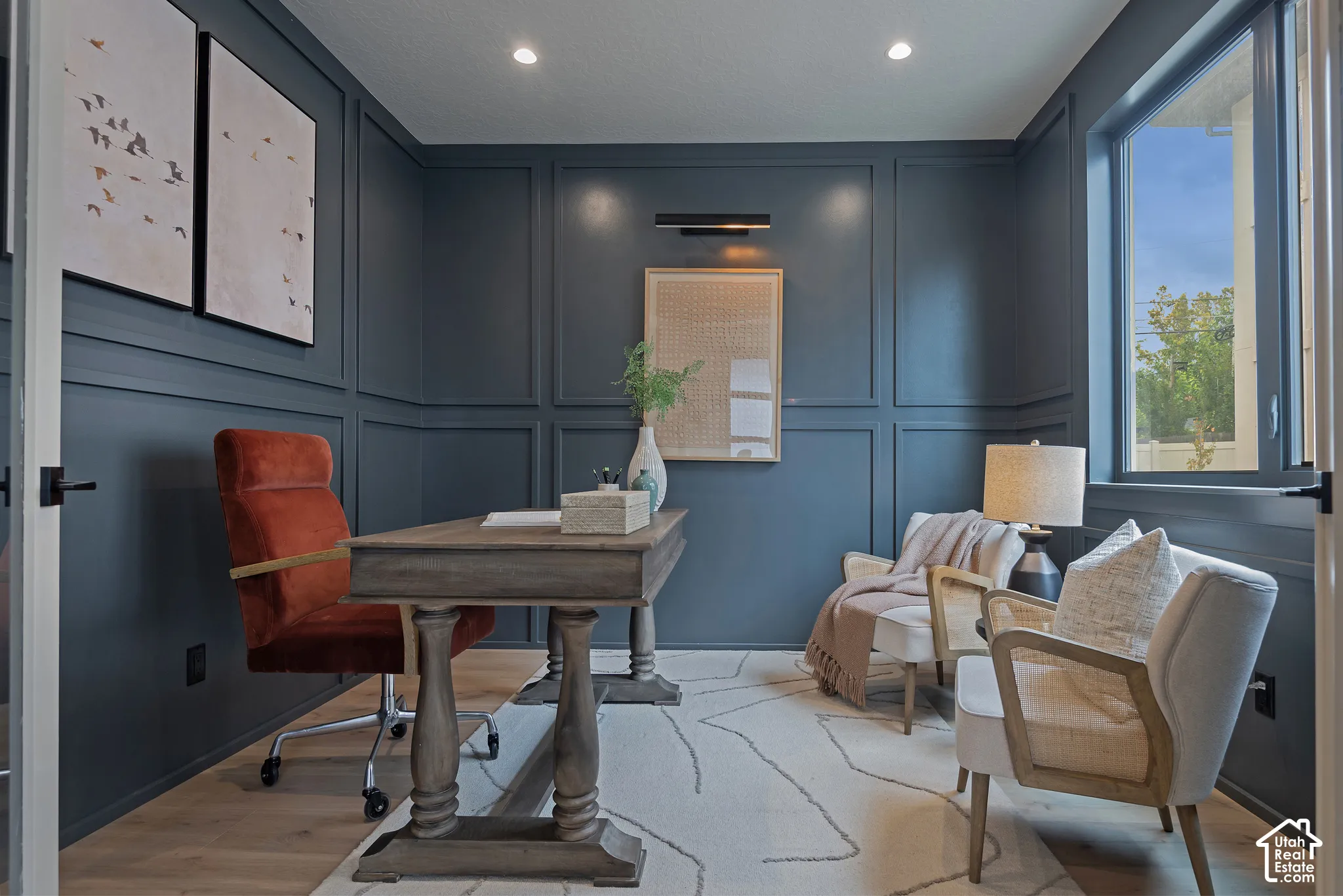 Room featuring floor-to-ceiling wainscoting, wood-finish flooring, recessed lighting, and a wall-mounted picture light