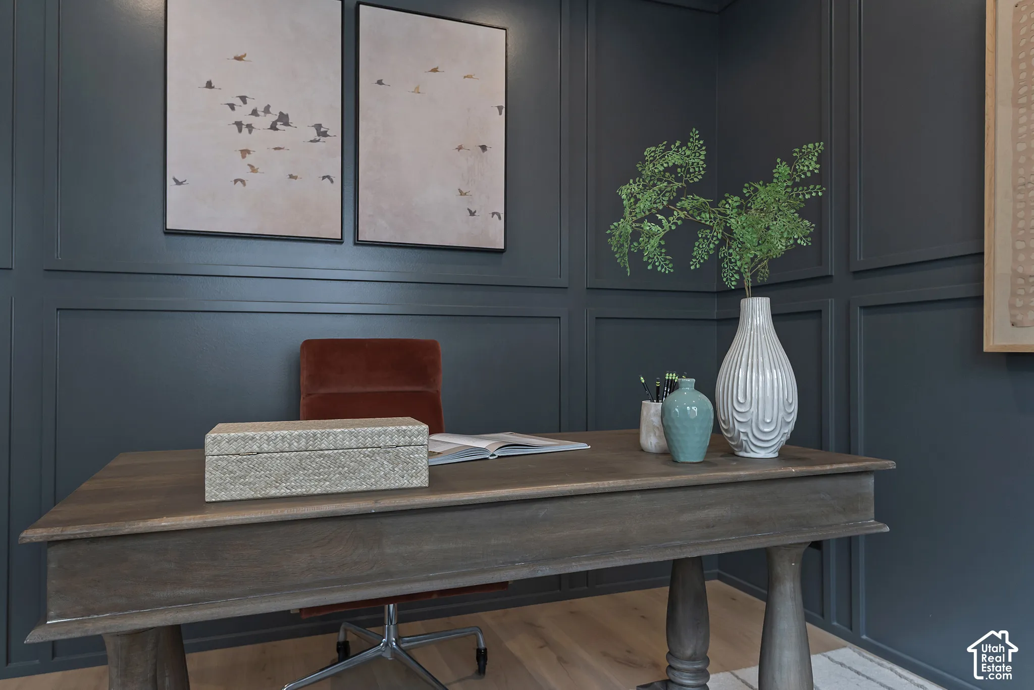 Dark-toned walls featuring applied wall molding and wood-finish flooring