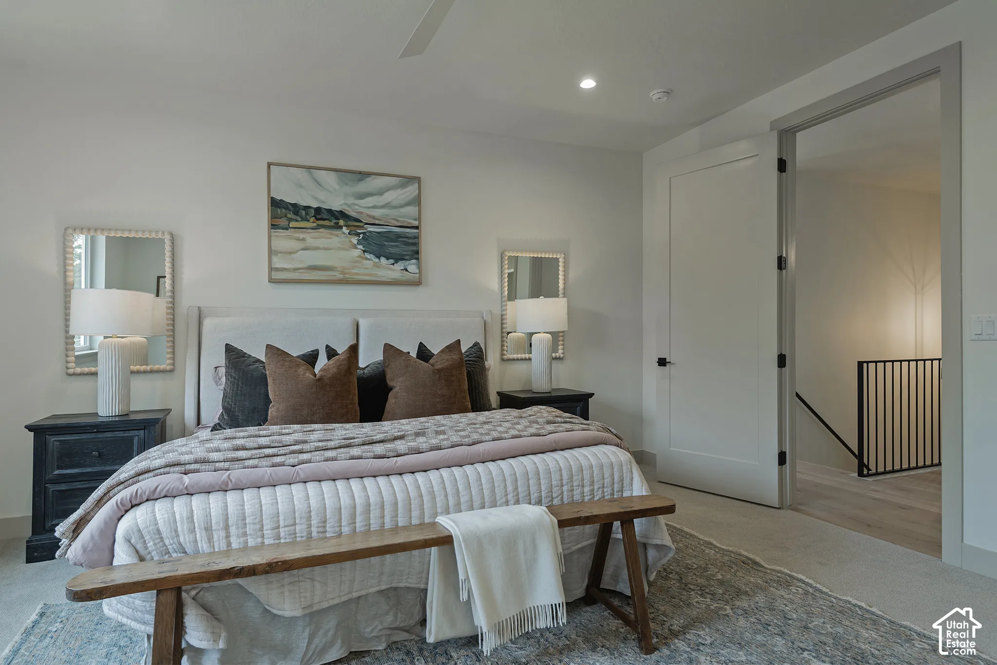 Neutral walls, ceiling fan, recessed lighting, solid-core interior door, and metal baluster stair railing