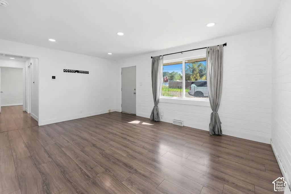 Interior space featuring wood-finish flooring, white painted horizontal paneled walls, and recessed ceiling lighting